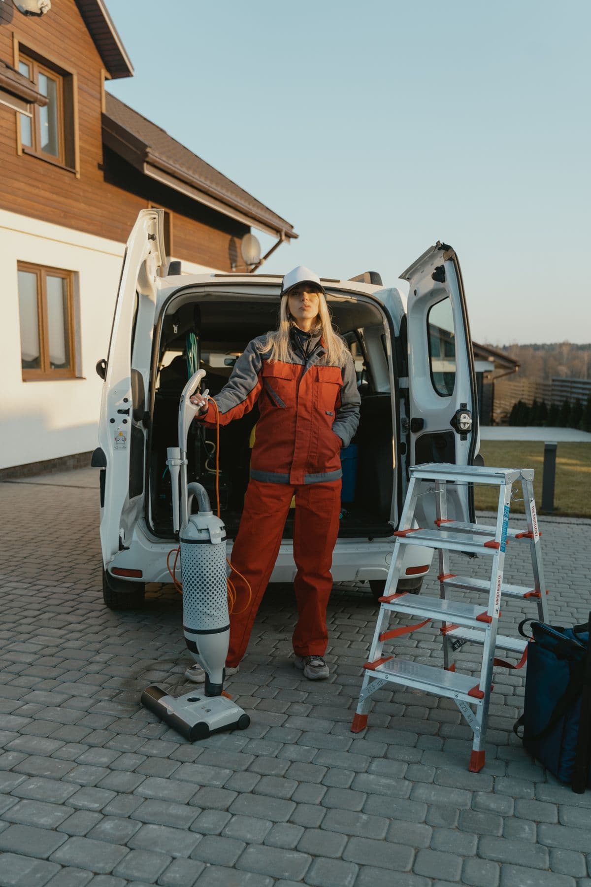 Independent cleaning professional preparing for a job beside a work vehicle